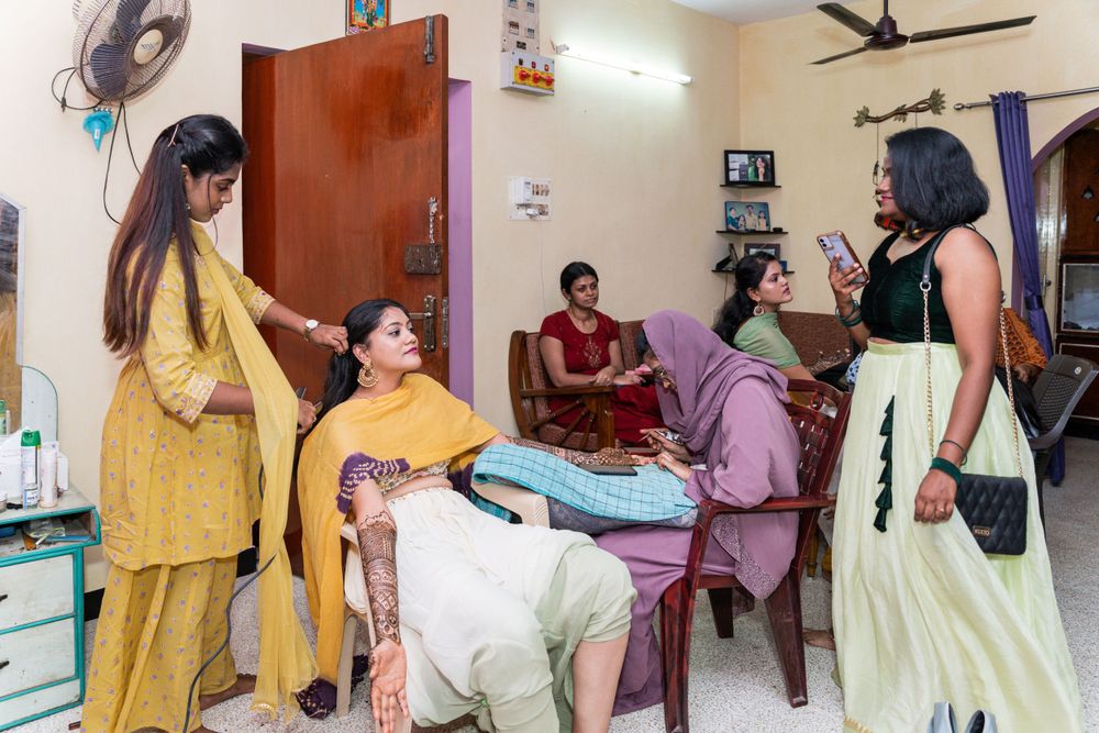 Women gathered in a room for traditional henna application ceremony.