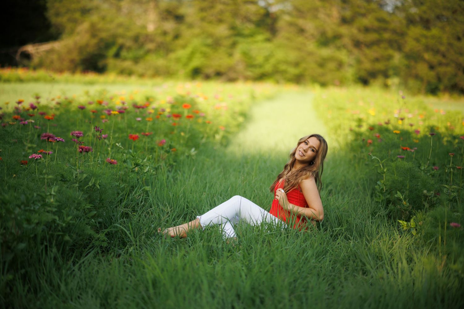 Person in red top relaxing in sunny meadow with wildflowers.