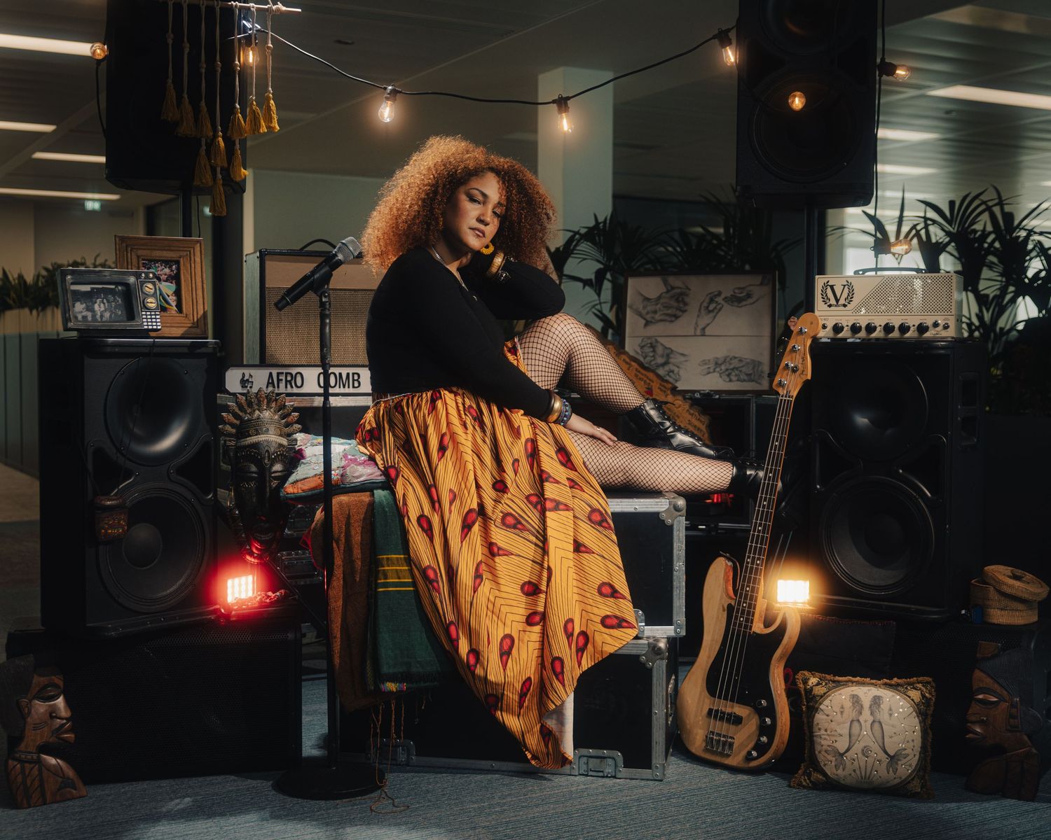 Artistic indoor photo shoot setup with speakers, instruments, and ambient lighting.