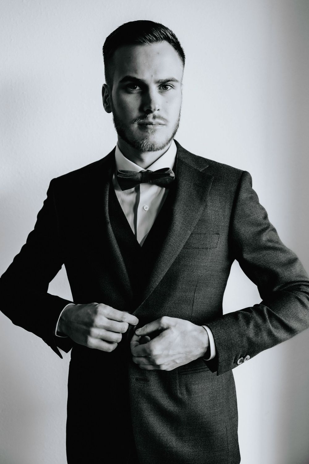 Dramatic black and white portrait series showing a suited figure in various dynamic poses.