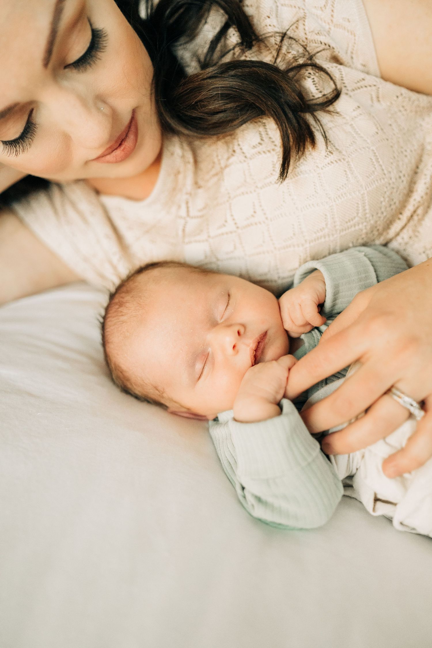 Mom cuddling newborn during in home lifestyle newborn session