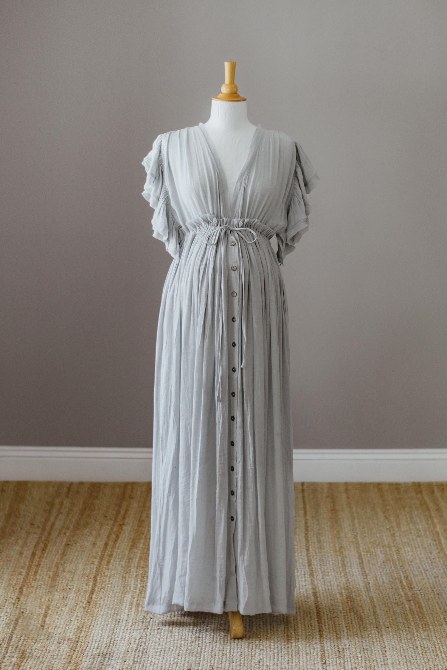 Light grey flutter sleeve maternity dress with button front detail on display.