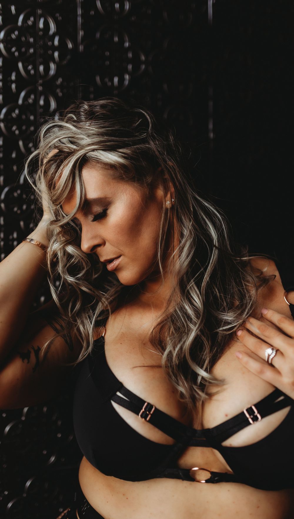 Sensual portrait featuring soft lighting and textured wallpaper background.