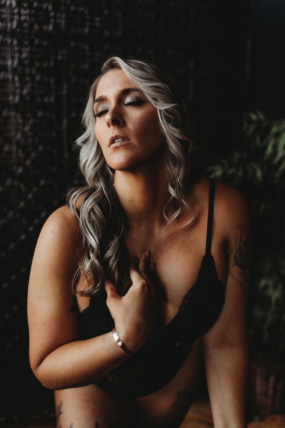 Intimate portrait with dramatic lighting against dark textured background.