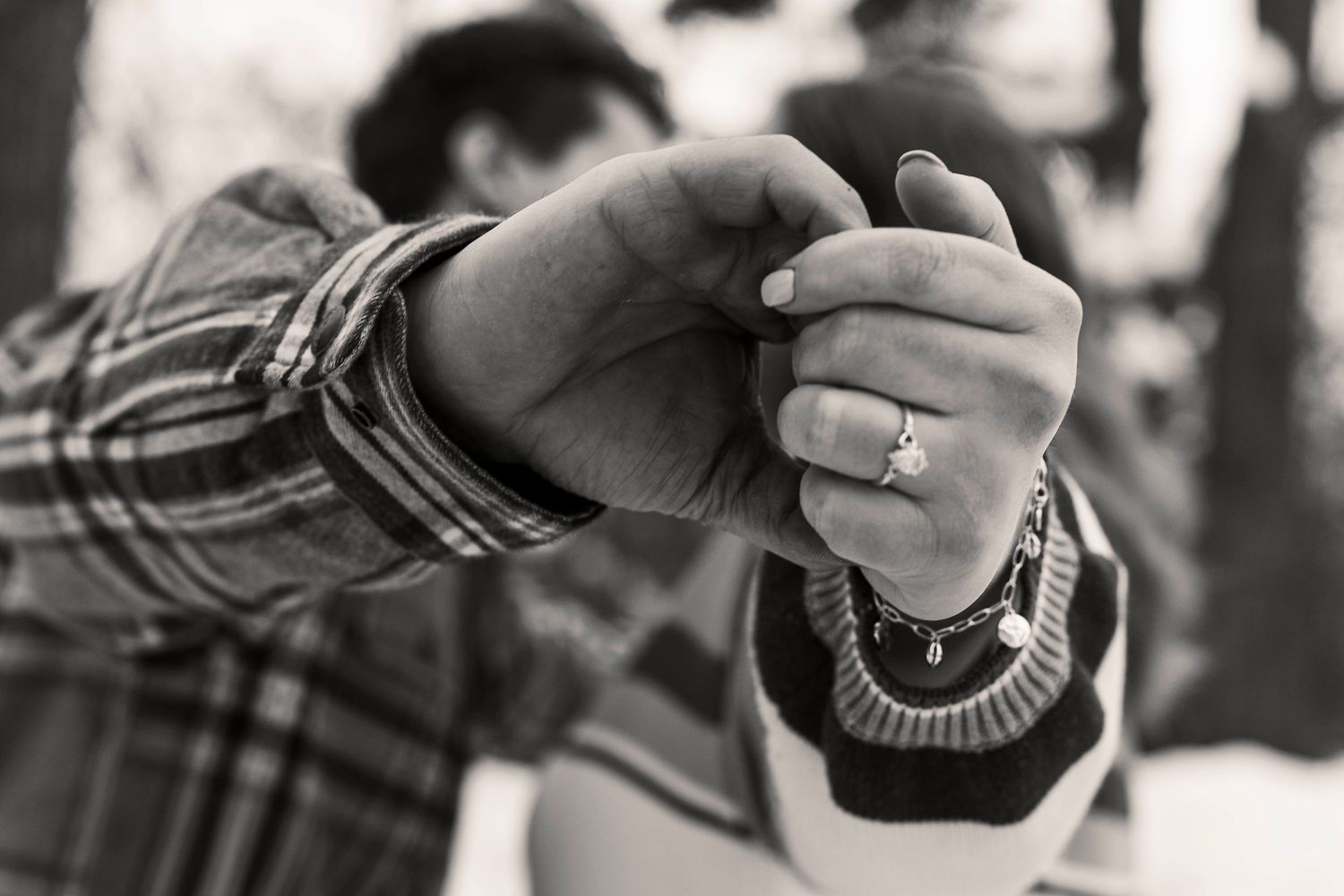 Close up of an engaged man and women's hands as they kiss in the background in Milaca, Minnesota