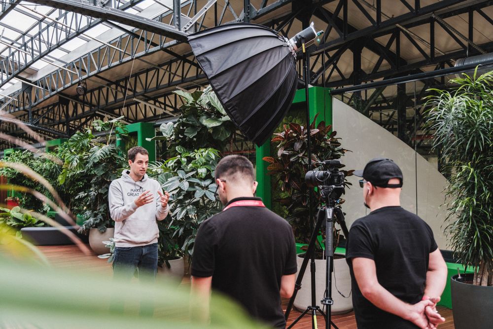 Behind the scenes photo shoot setup with lighting equipment and camera crew.