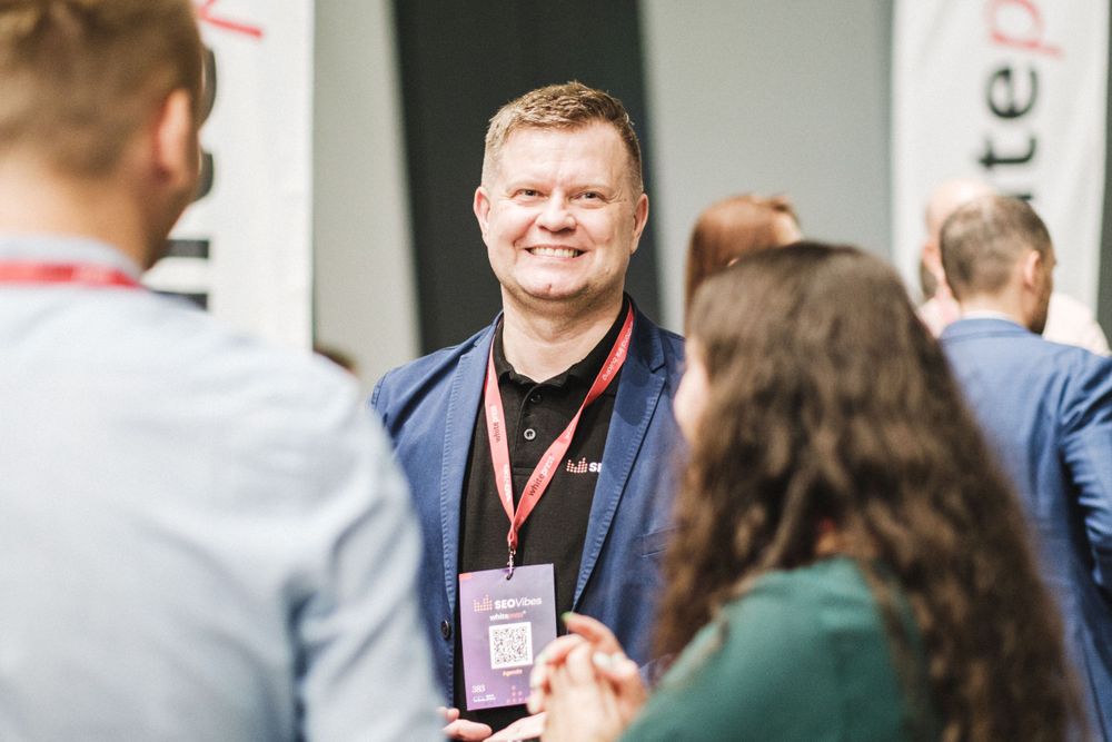 Event attendee wearing name badge networking with other participants.