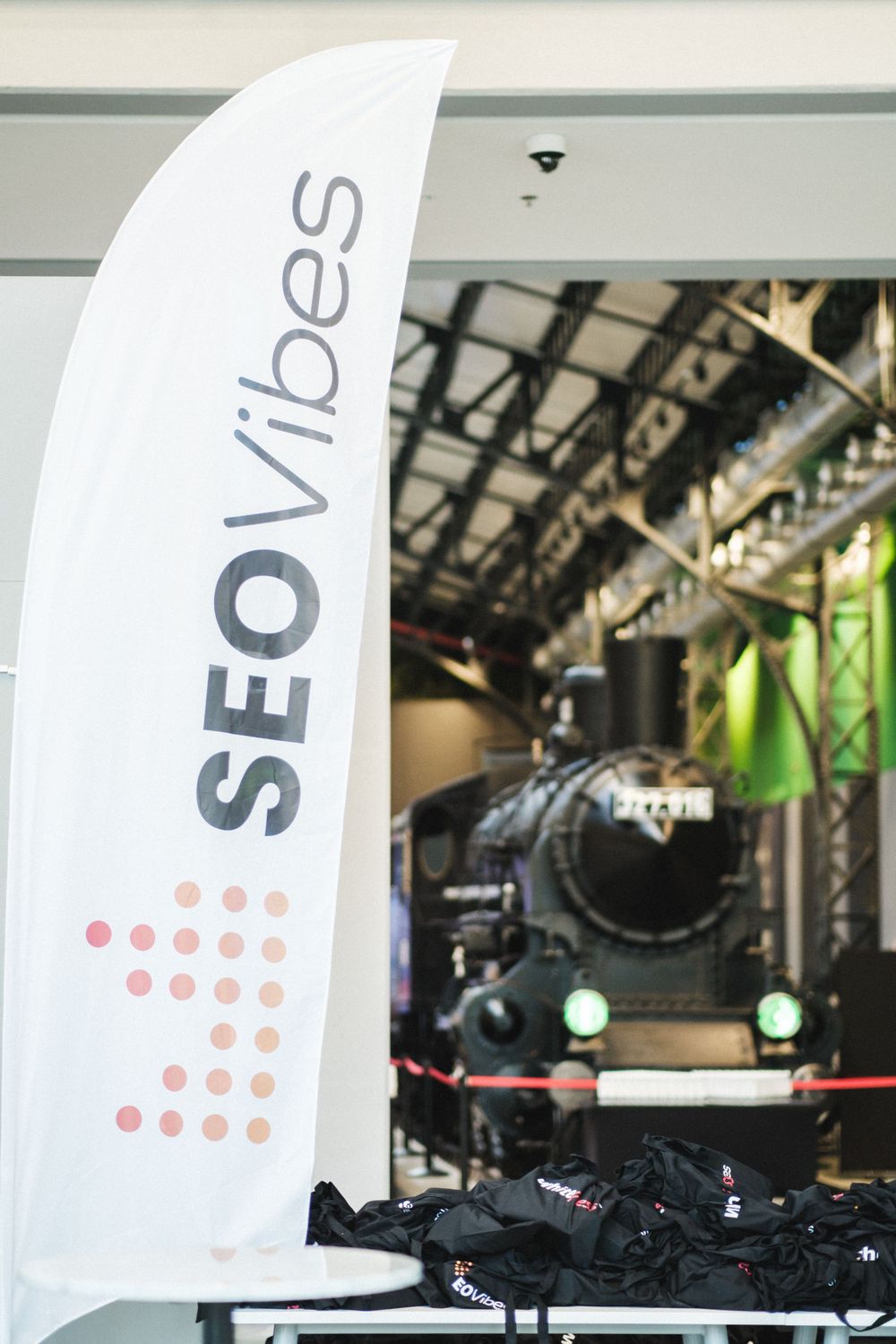White SEO Vibes branded feather flag banner displayed at conference venue.