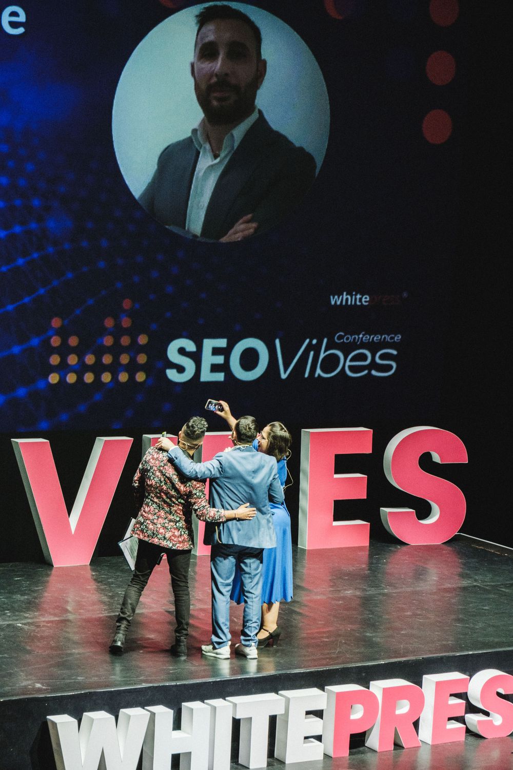 SEO Vibes event stage with large text display and projection screen above.