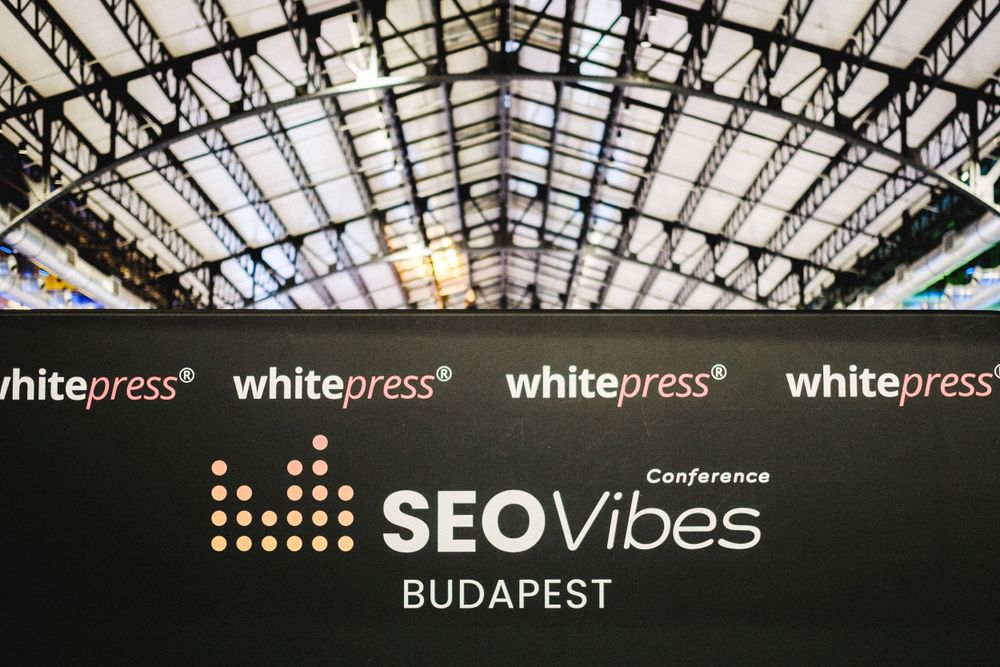 SEO Vibes Budapest conference branding displayed under industrial glass ceiling.