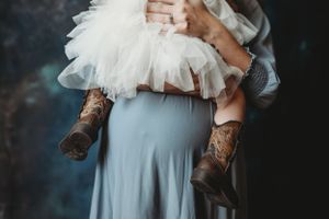 Close-up detail of white tulle dress and gray fabric in studio setting.
