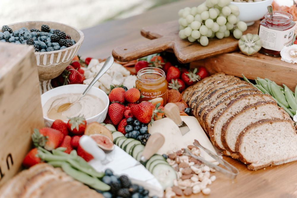 Fresh fruit, grapes, and charcuterie spread displayed on a rustic wooden table.
