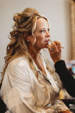 Getting ready scene showing final touches of wedding day makeup preparations.