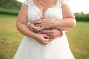 Close-up detail shot of a lace wedding dress with delicate jewelry accessories.