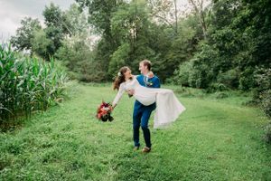 A celebration of love as a couple spins and dances on a grassy path beside tall corn stalks.