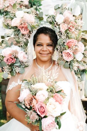 Beautiful bridal portrait surrounded by pink and white floral arrangements with eucalyptus greenery.