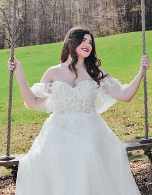 Romantic wedding dress captured in an outdoor setting with rolling green hills.