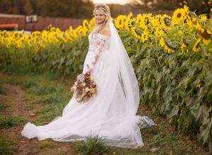 Elegant bridal portrait against a field of blooming sunflowers at golden hour.