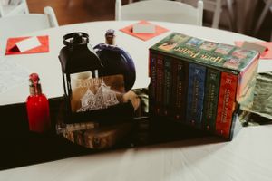 Harry Potter books displayed with vintage bottles and decorative elements on a table setting.
