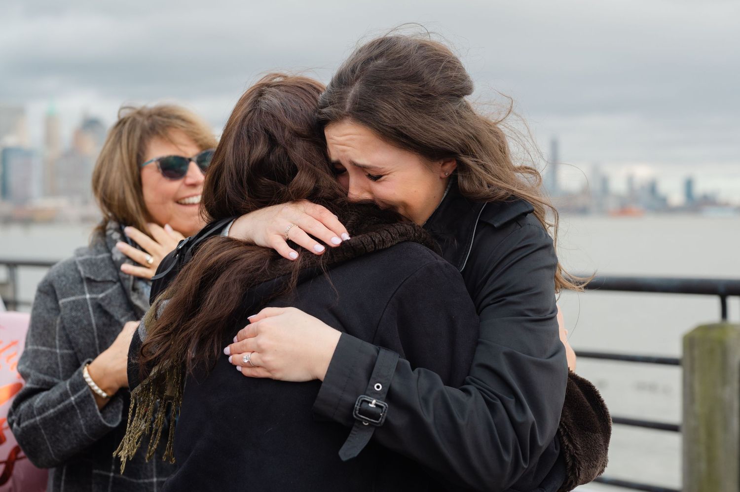 Sisters hugging after surprise proposal at Liberty State Park