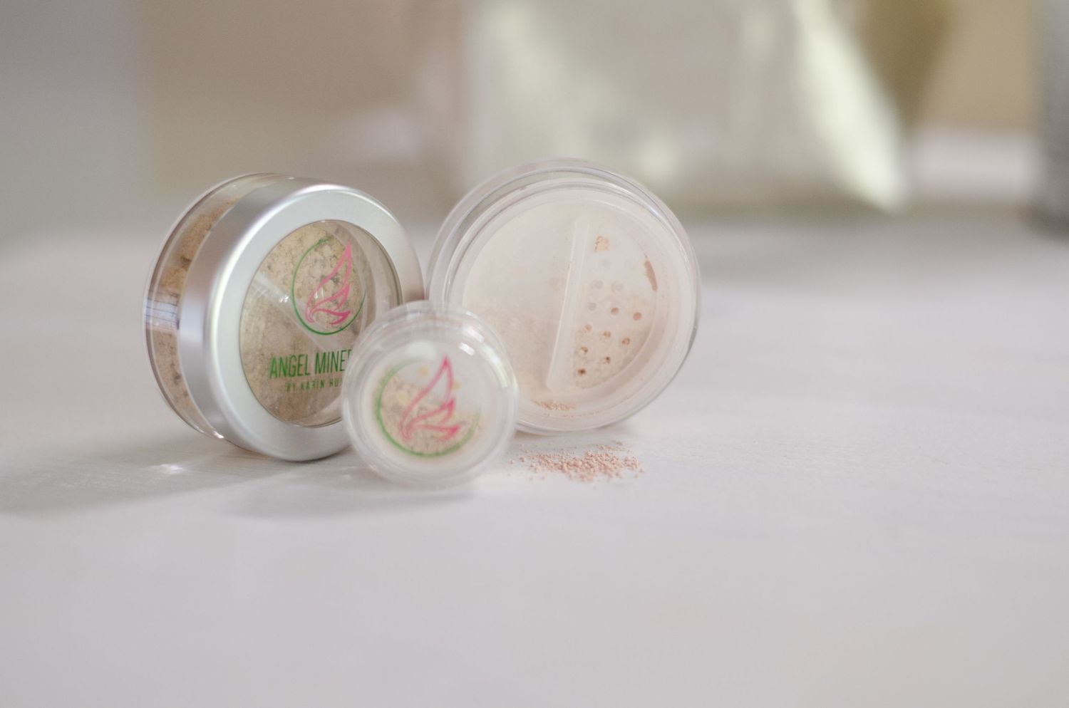 Beauty product containers with delicate floral patterns displayed in soft lighting.
