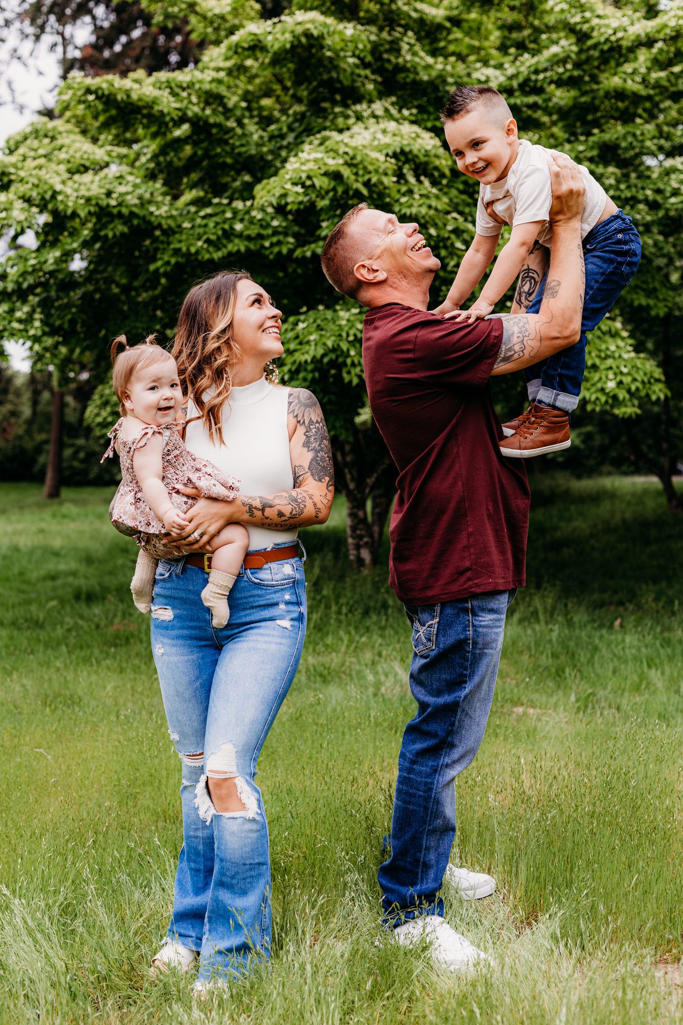 Family enjoying playful moment together outdoors in green summer setting.