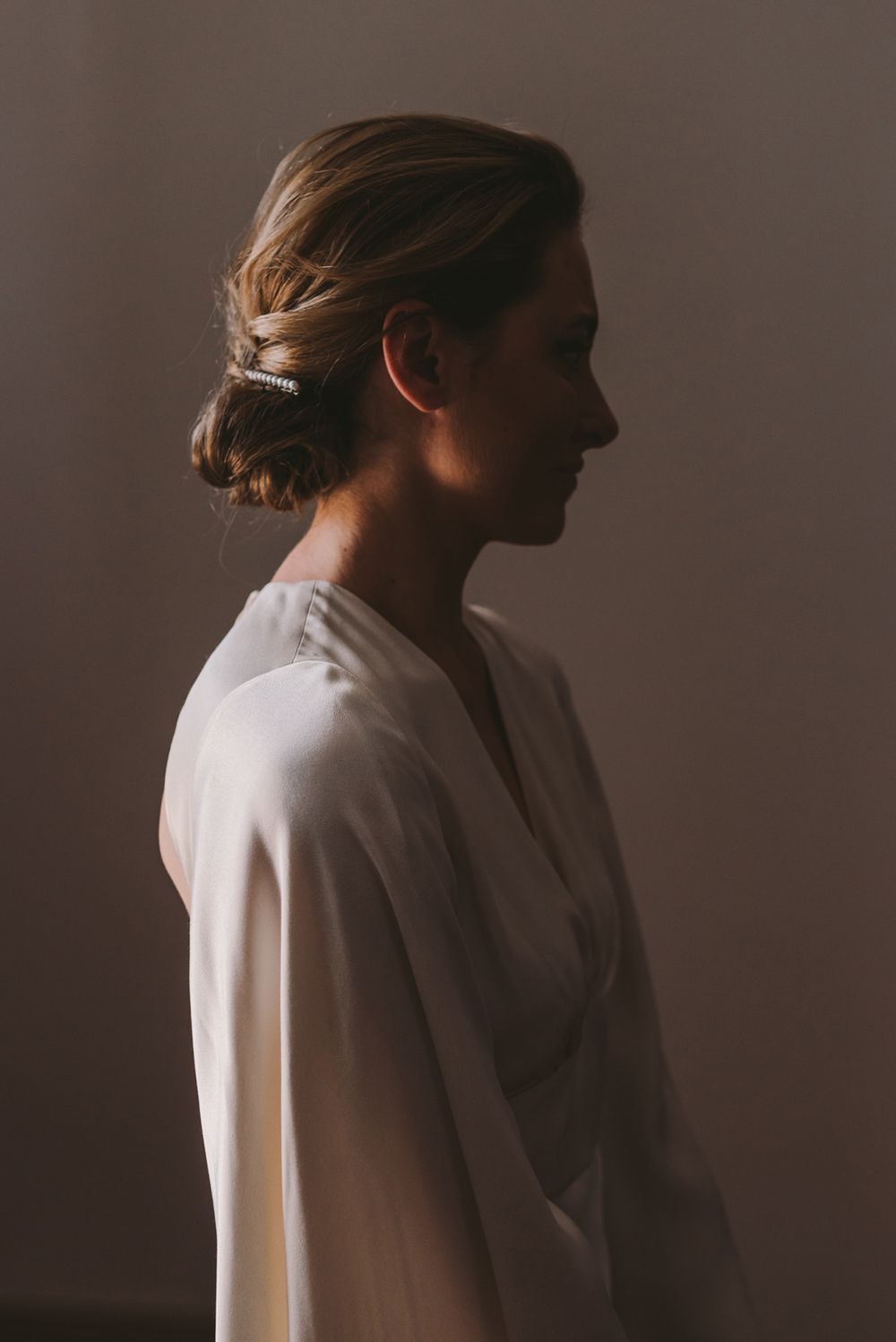 Artistic silhouette of person in white robe against dark background.