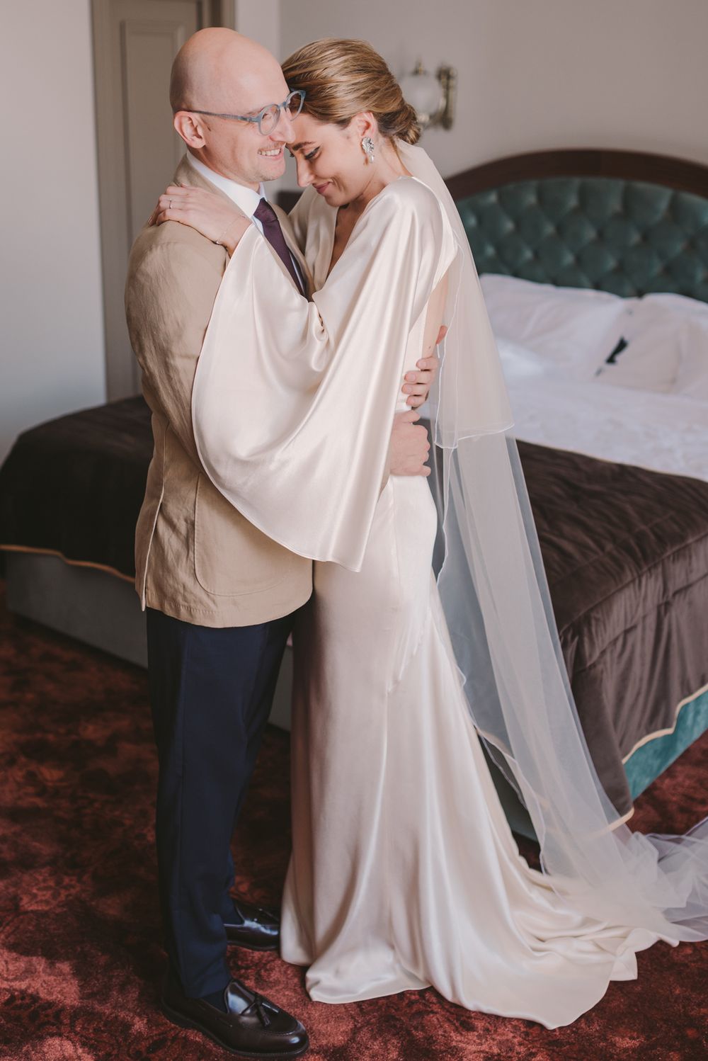 Intimate dance between a couple in formal attire on a patterned carpet.