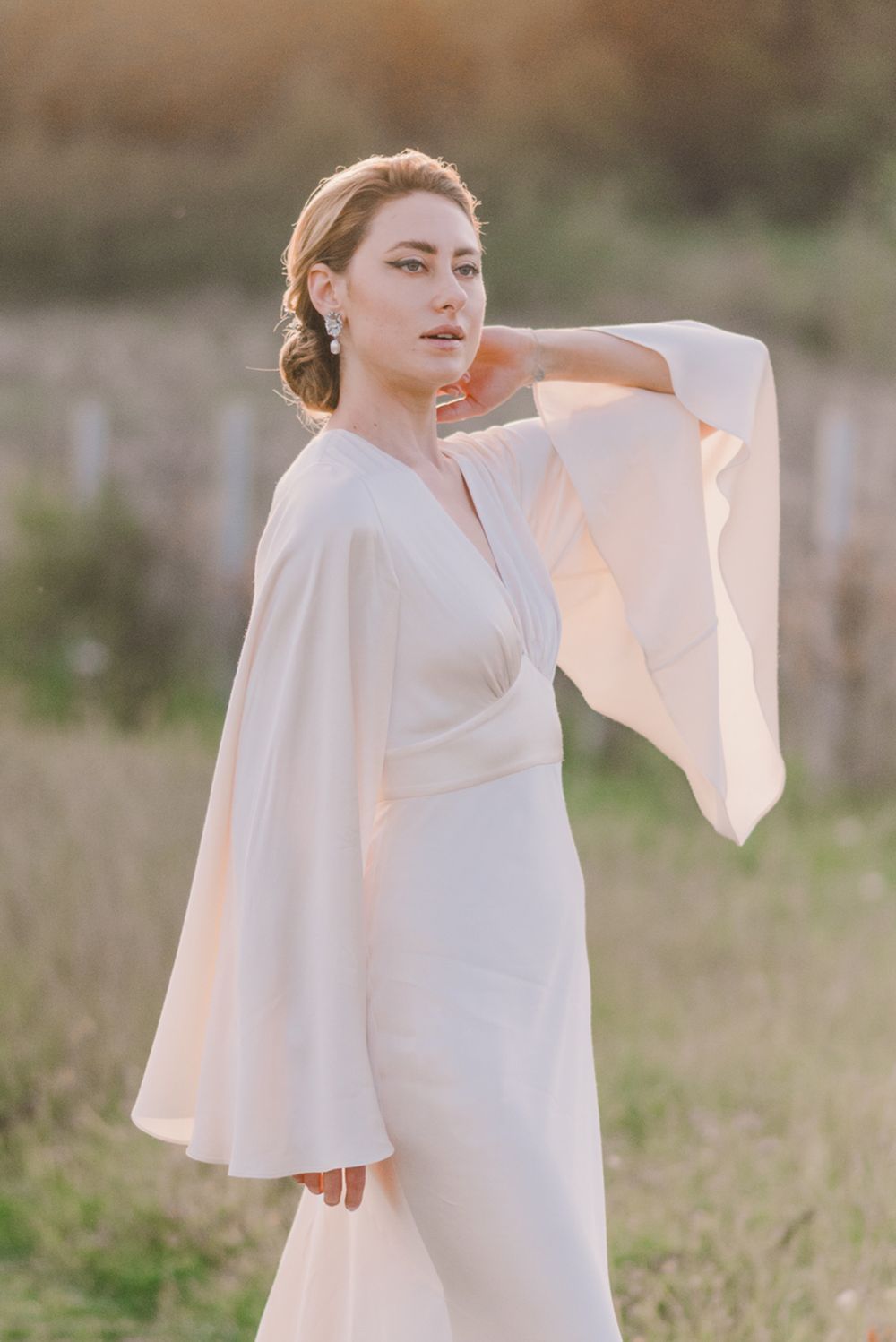 Ethereal white dress with flowing sleeves captured in a series of graceful movements at golden hour.
