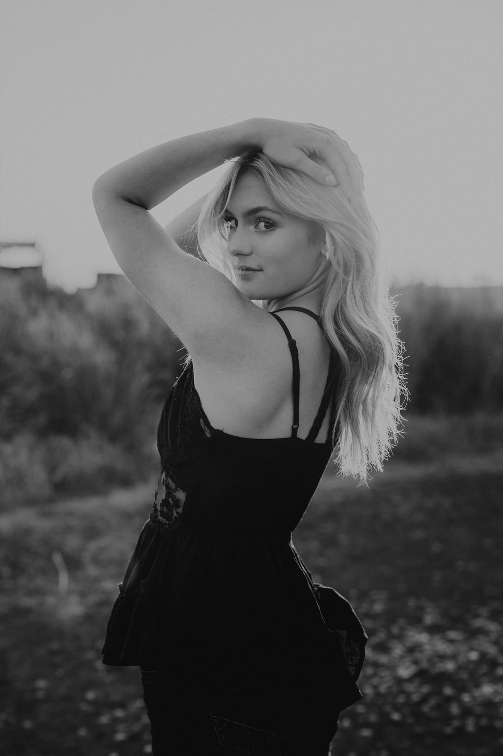 girl standing in an open field looking back