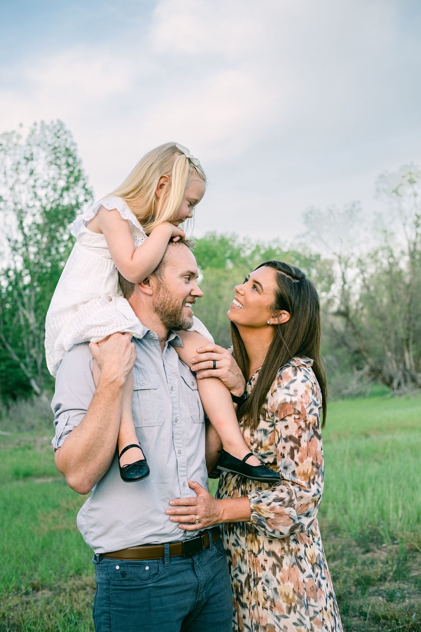 outdoor family smiling at each other in Salt Lake City for portraits.