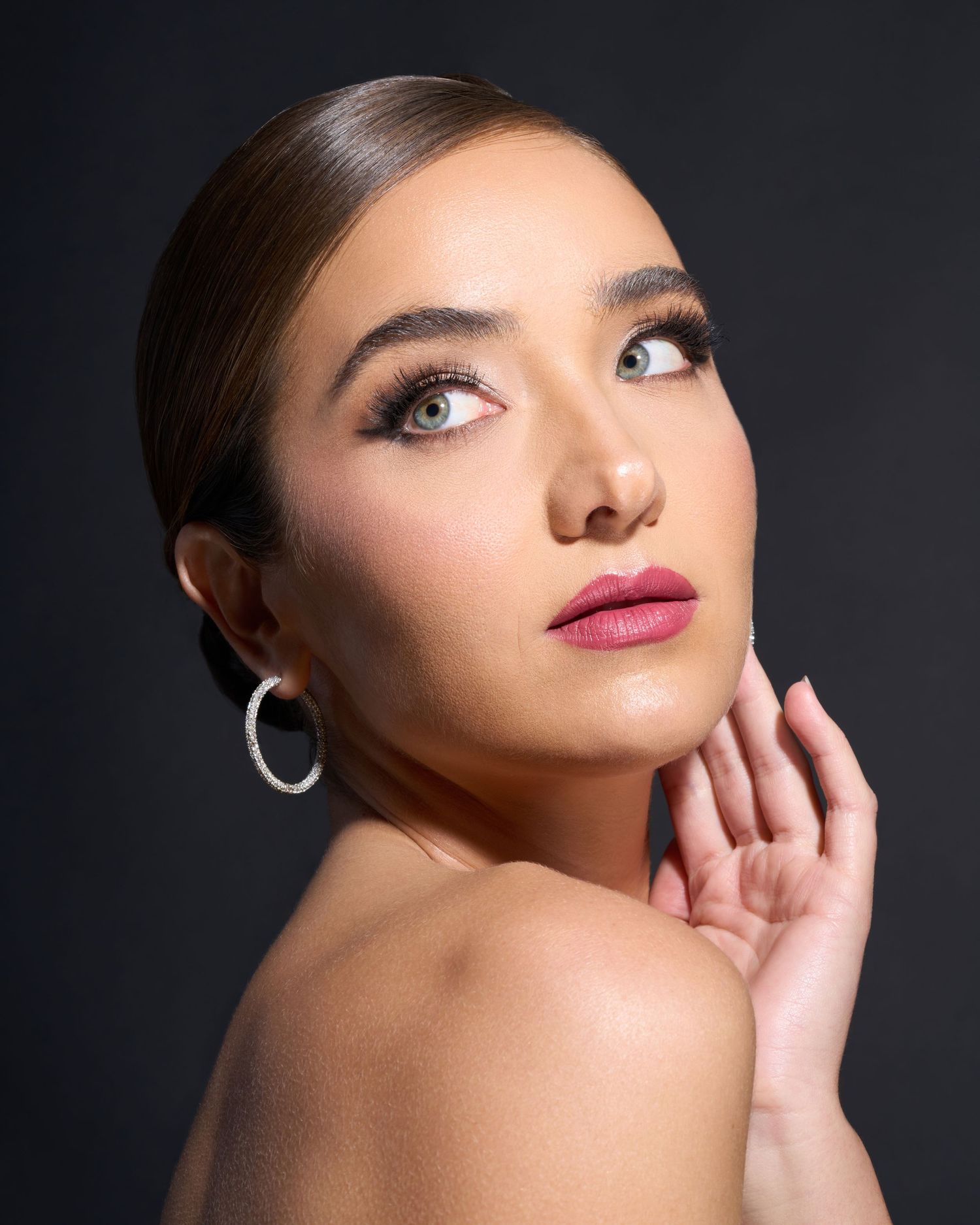Professional beauty portrait with dramatic lighting and luxury styling.