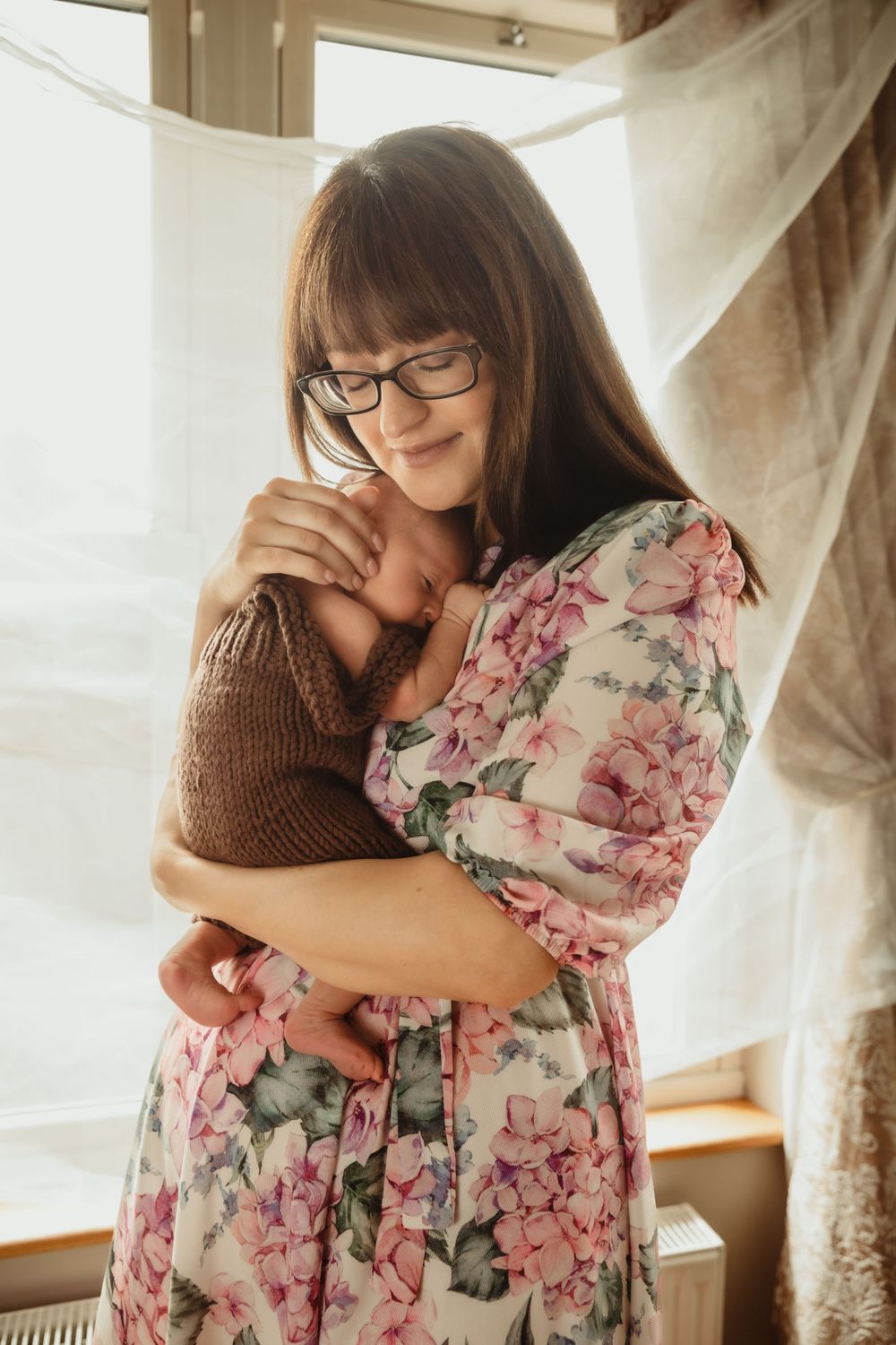 Newborn held by mother.