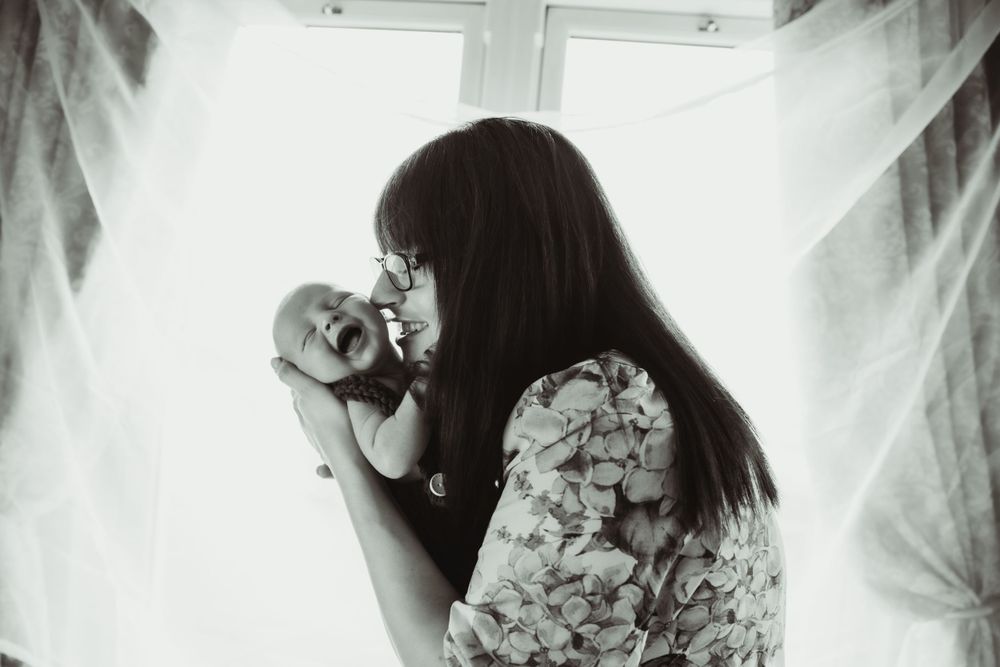 Newborn smiling with mother