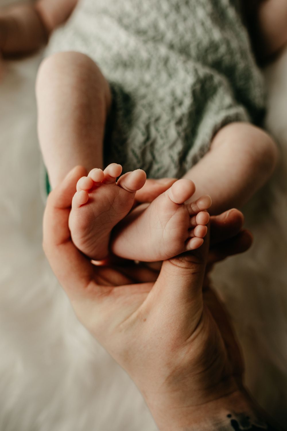 Newborn baby feet in father's hand