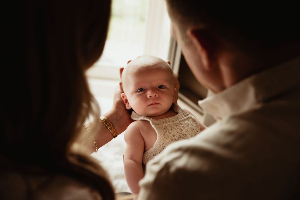 Newborn baby looks at parents