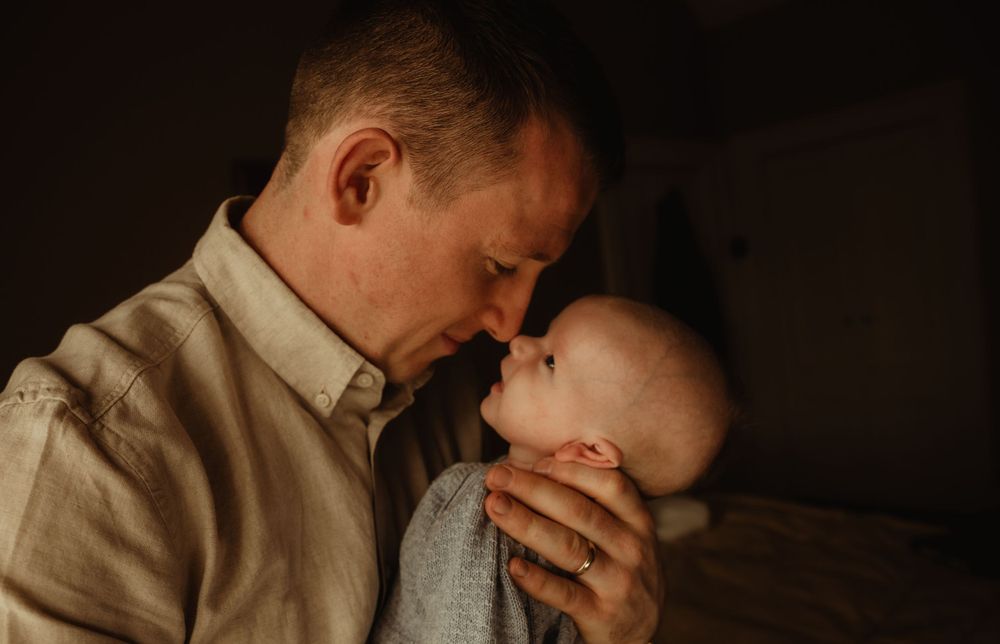 Newborn baby nose to nose with father