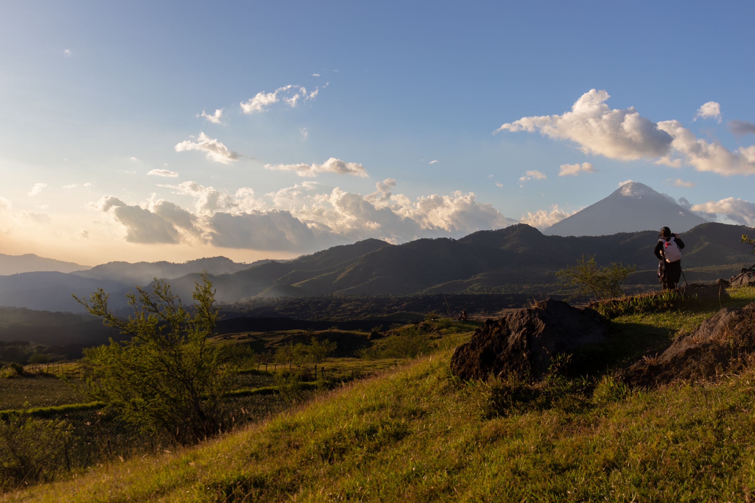 Dramatic mountain vista with sunlit peaks and scattered clouds in late afternoon light.