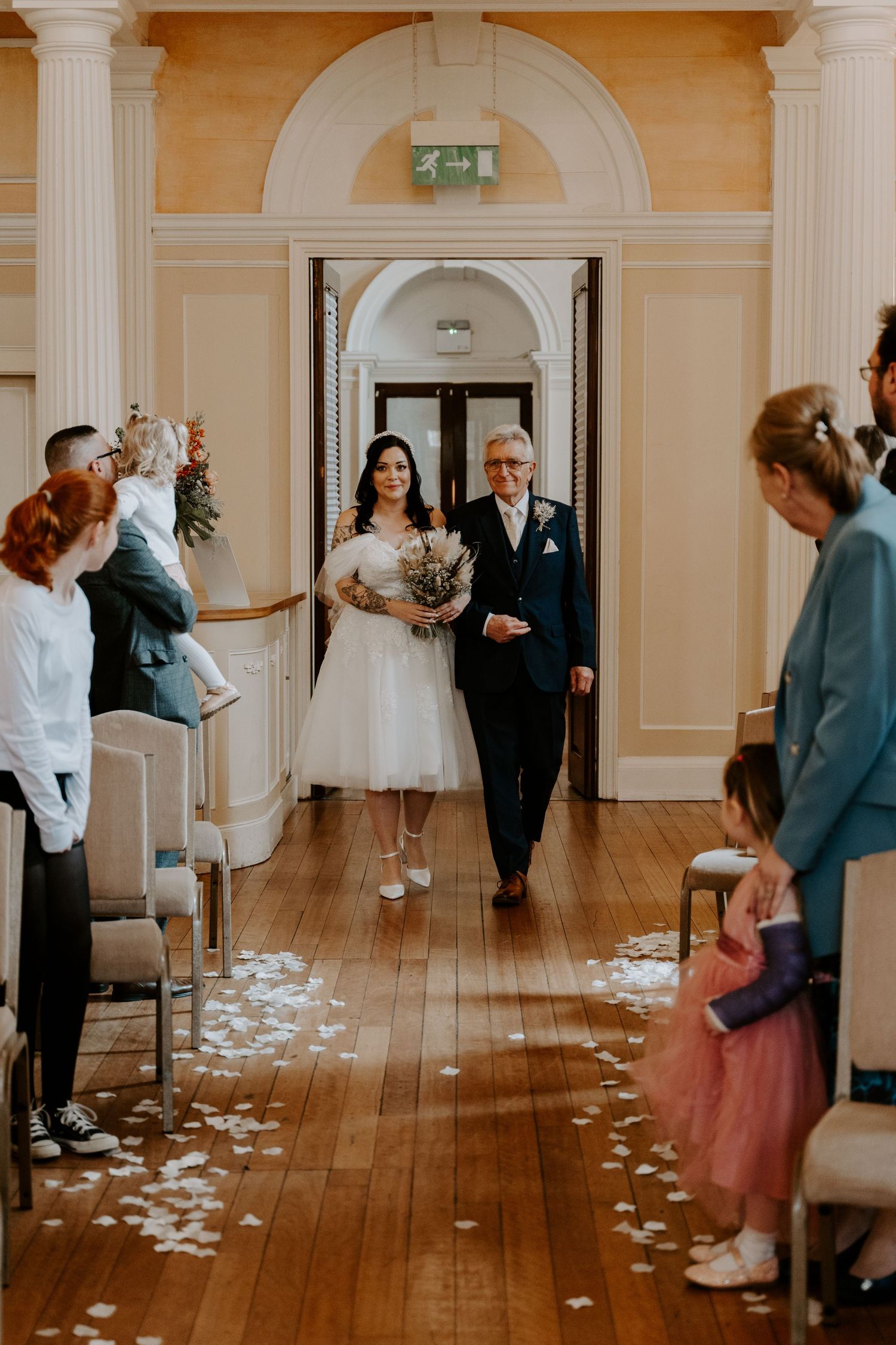 a bride and her dad walking down the aisle