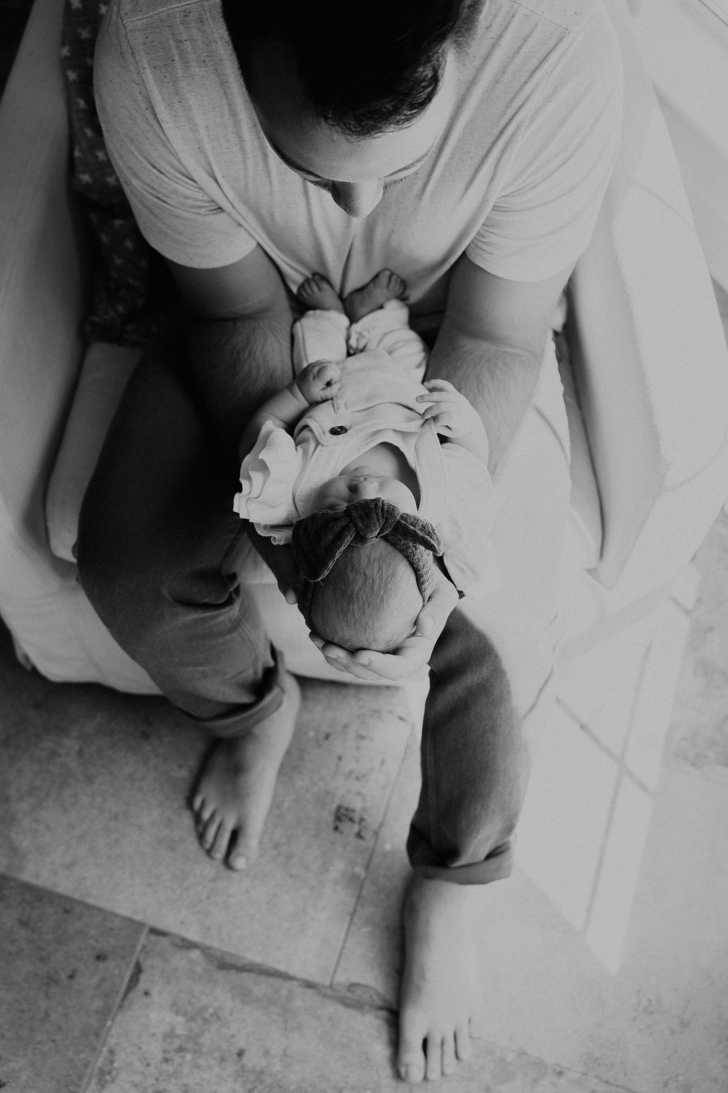 dad holding newborn baby at home sitting down. alex marie photography. newborn photos dallas.