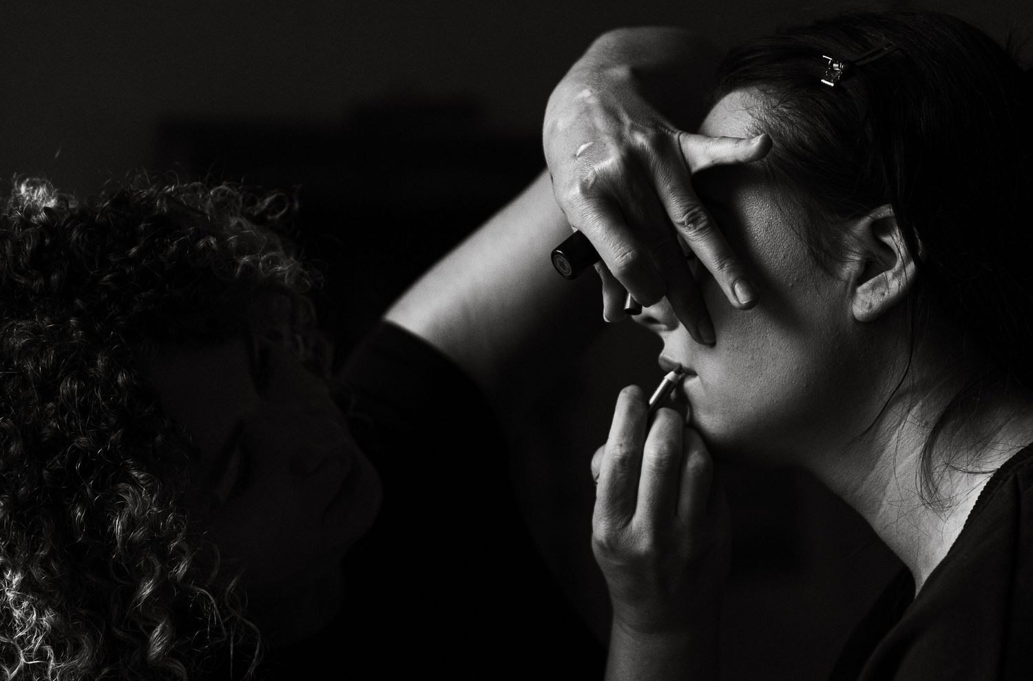 An artistic black and white portrait showing dramatic lighting and emotion.