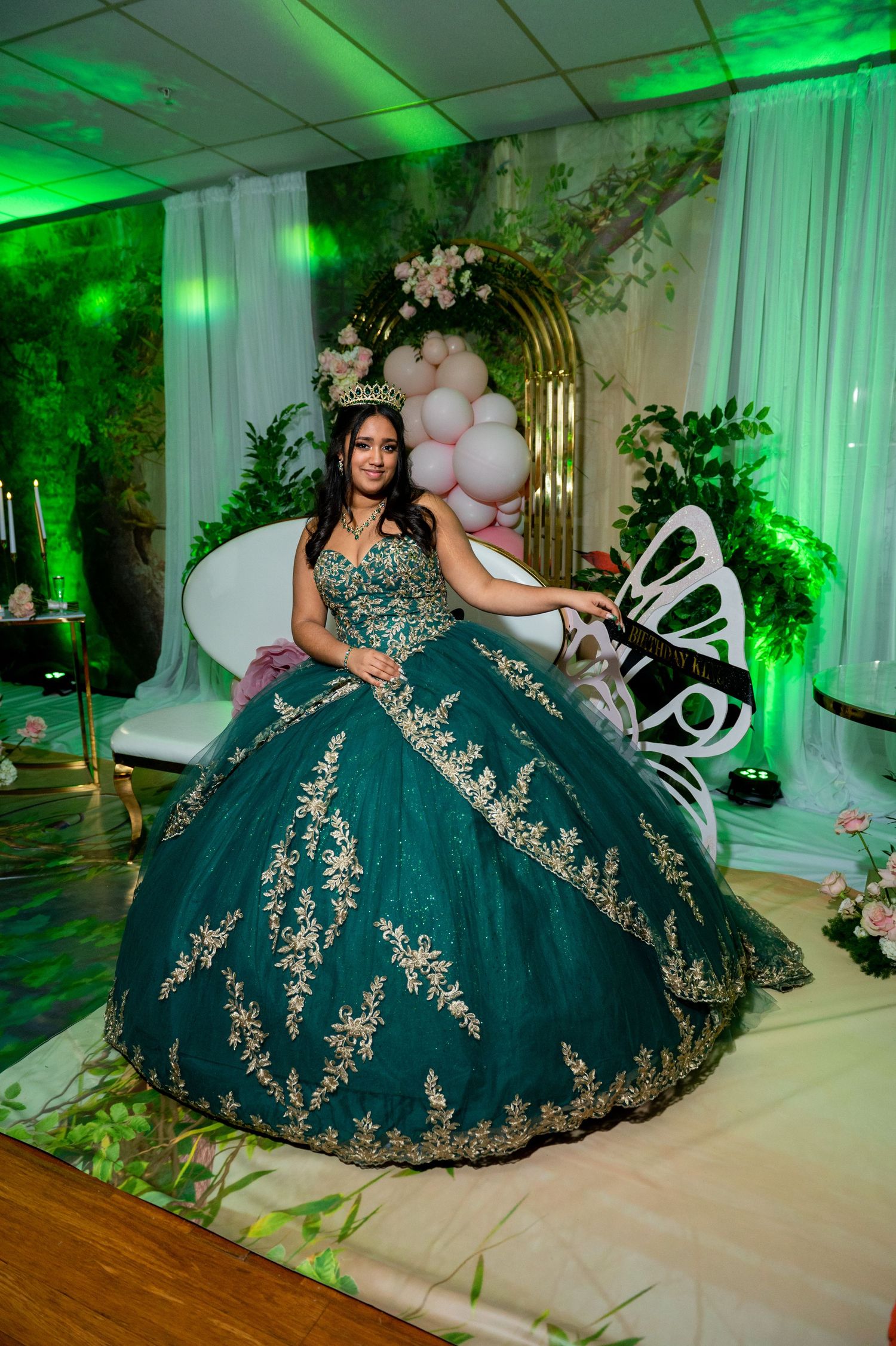 Stunning dark green quinceañera dress with intricate gold lace details and full tulle skirt.