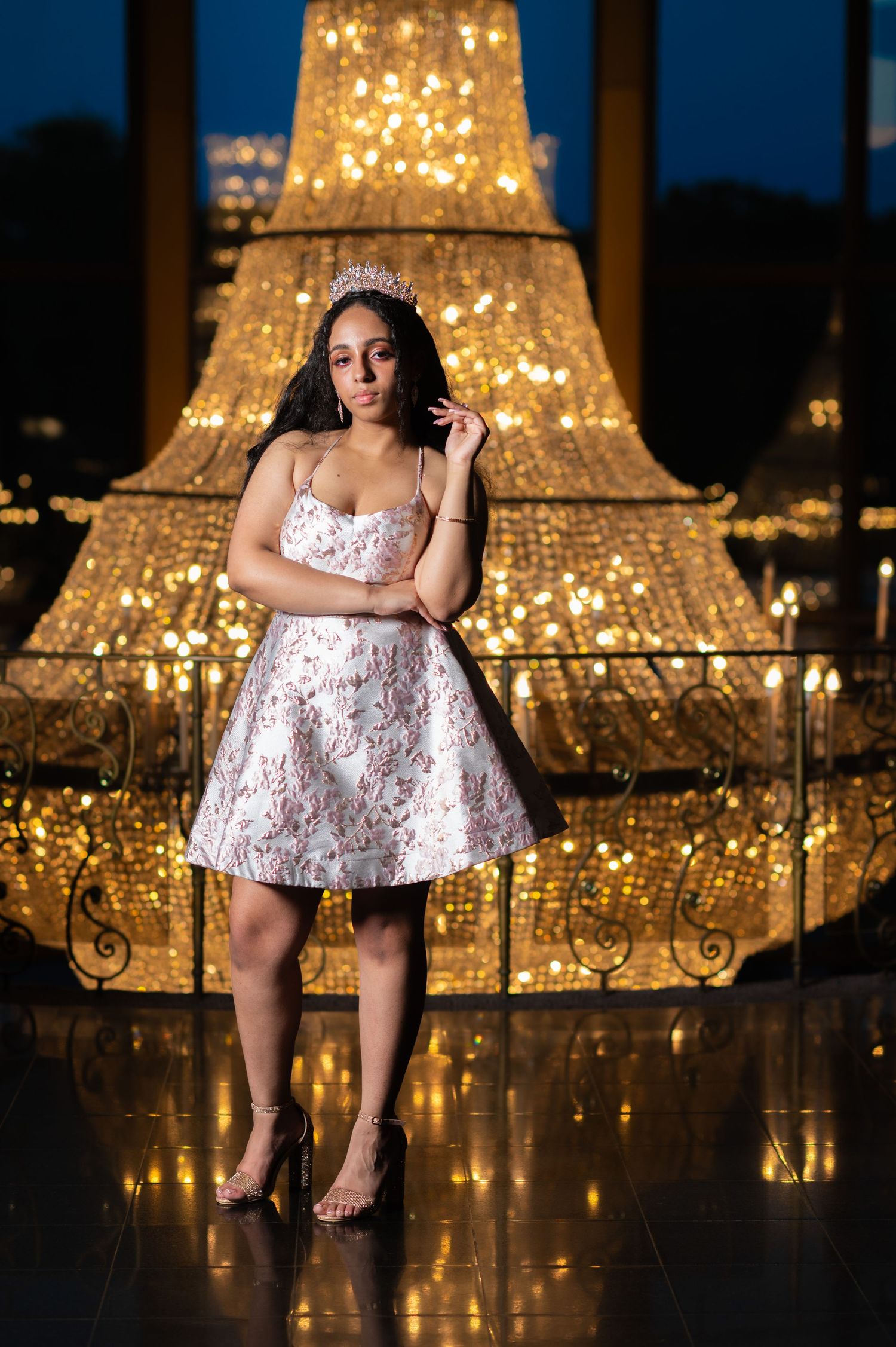 Short pink dress with crown photographed against glowing Eiffel Tower backdrop.