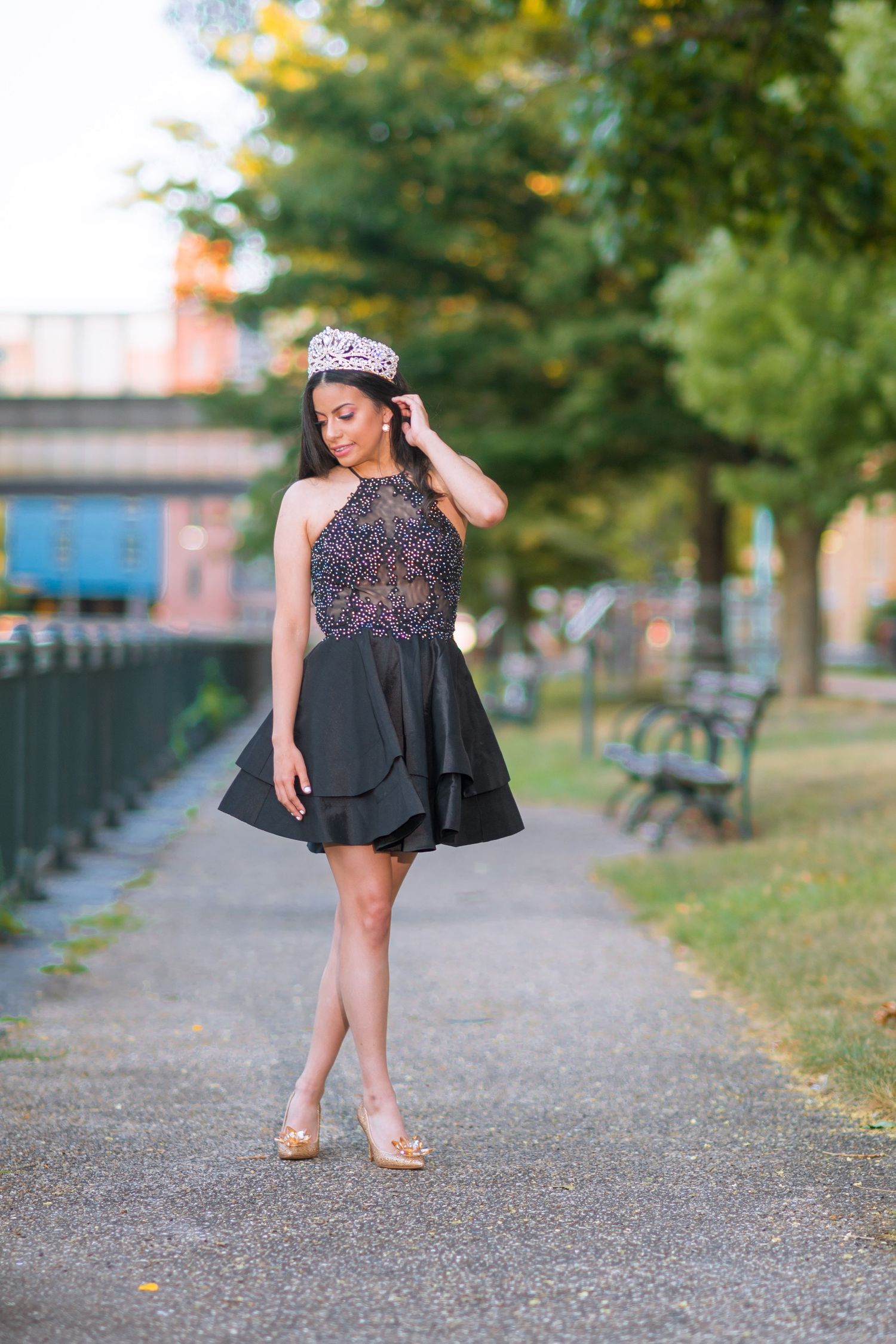 Short black beaded dress with crown photographed on autumn pathway with park benches.