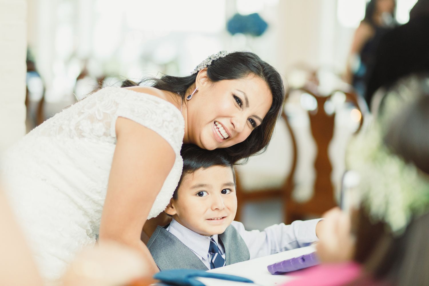 A joyful moment captured during a wedding reception with formal attire and decorative details.