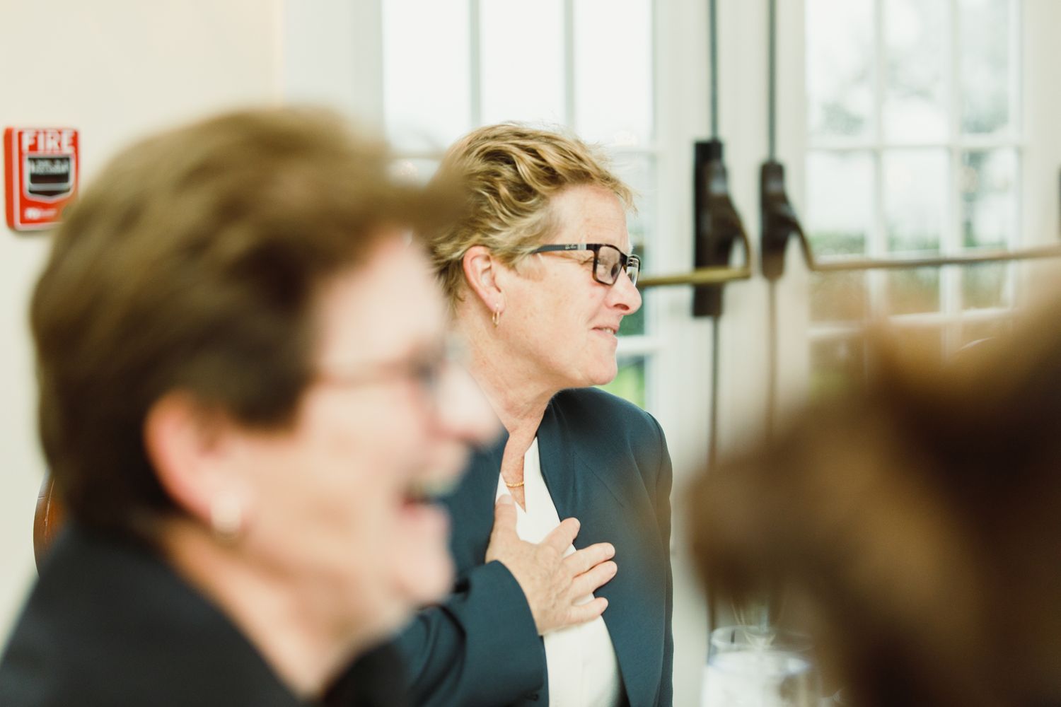 Event attendees engaged in animated conversation at a formal indoor gathering.