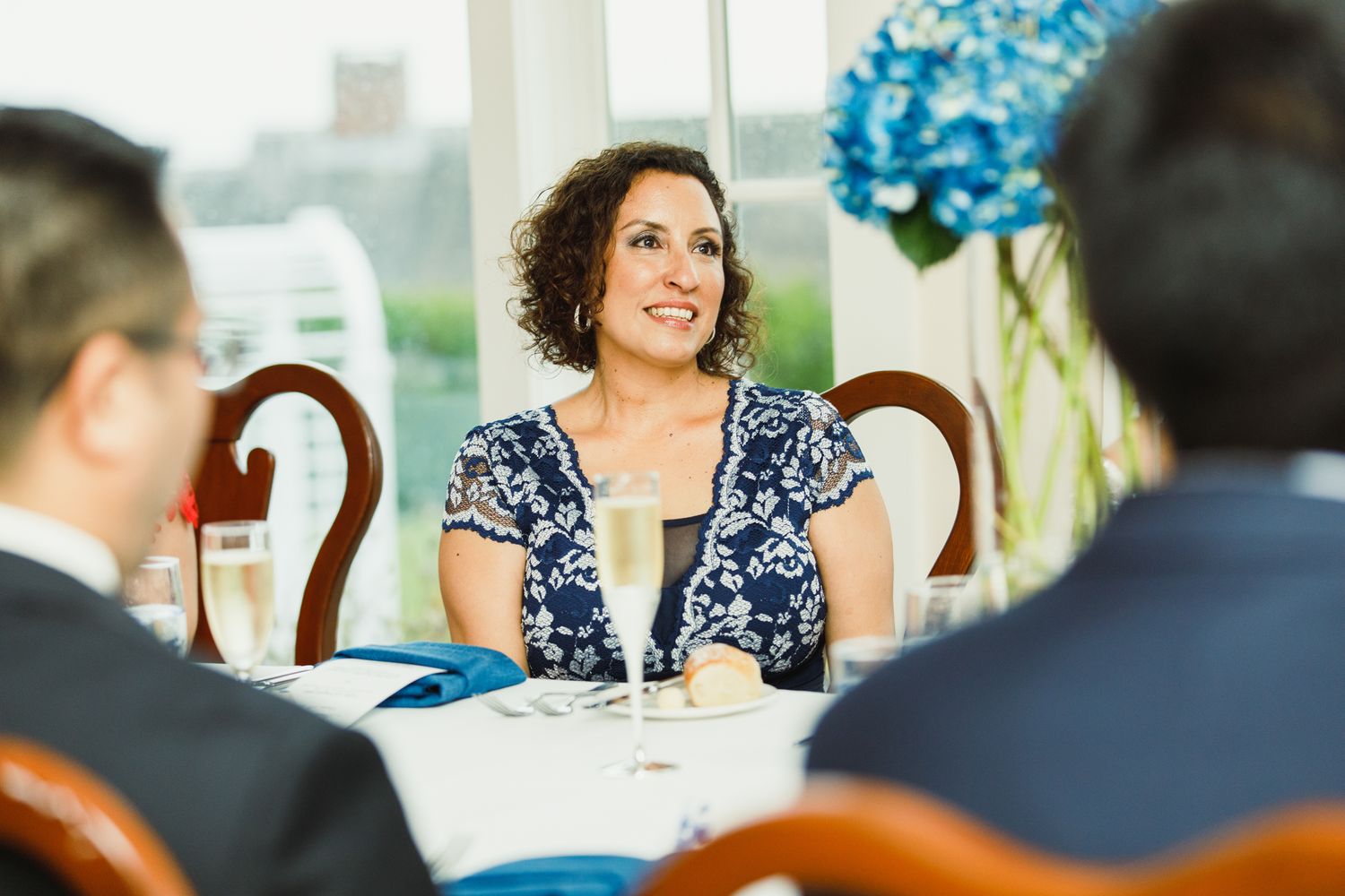 Guests share laughter and conversation during an elegant dinner reception.