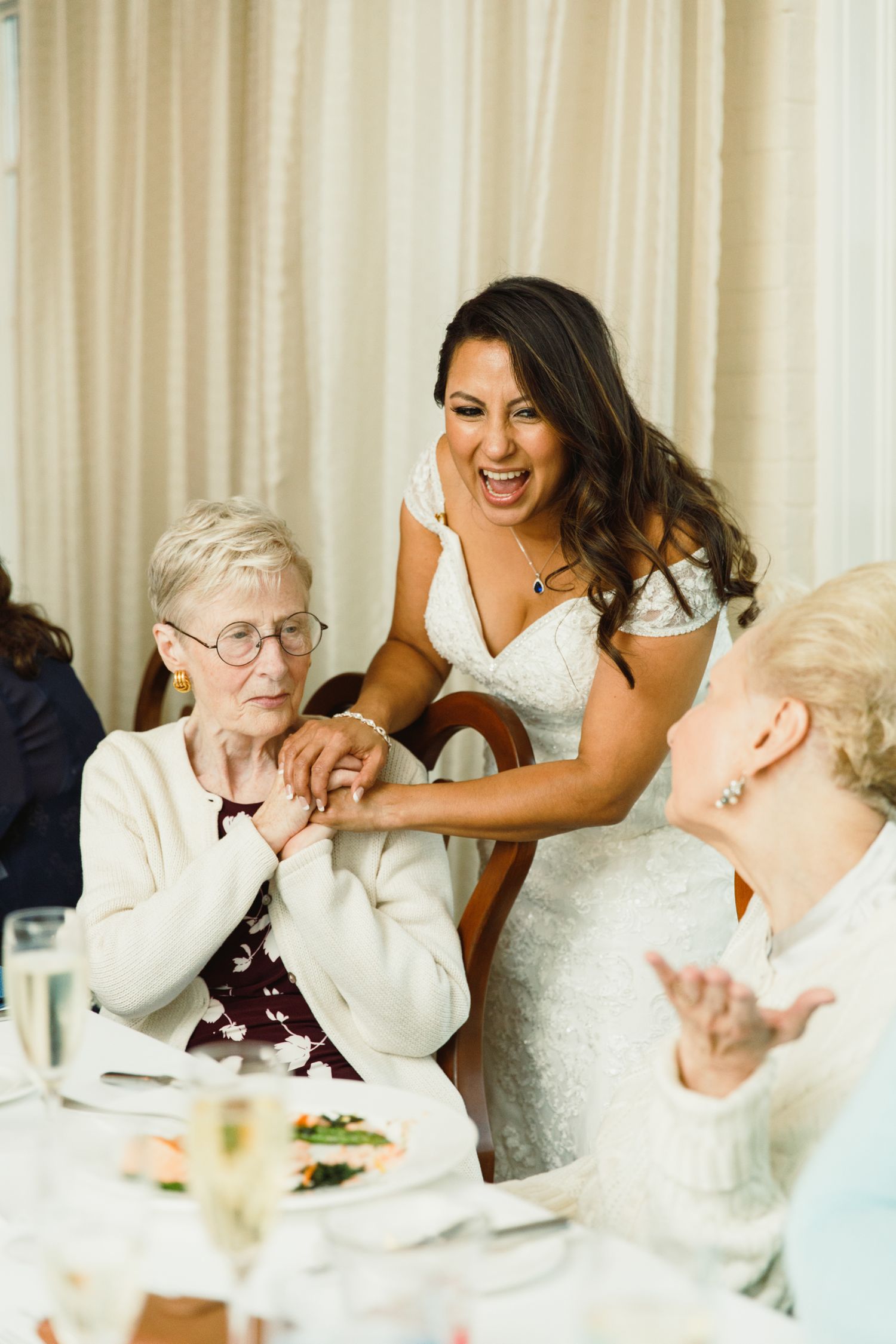Candid reactions of dinner guests during a heartwarming moment at a celebration.