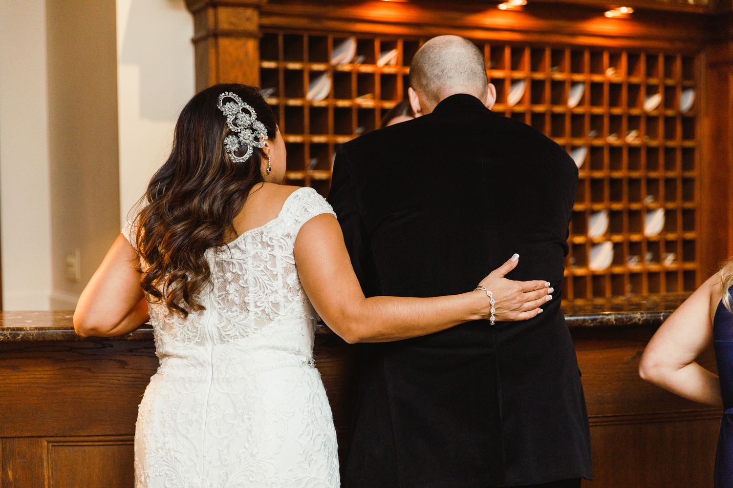 Wine rack display in warm lighting creates elegant ambiance at wedding venue.