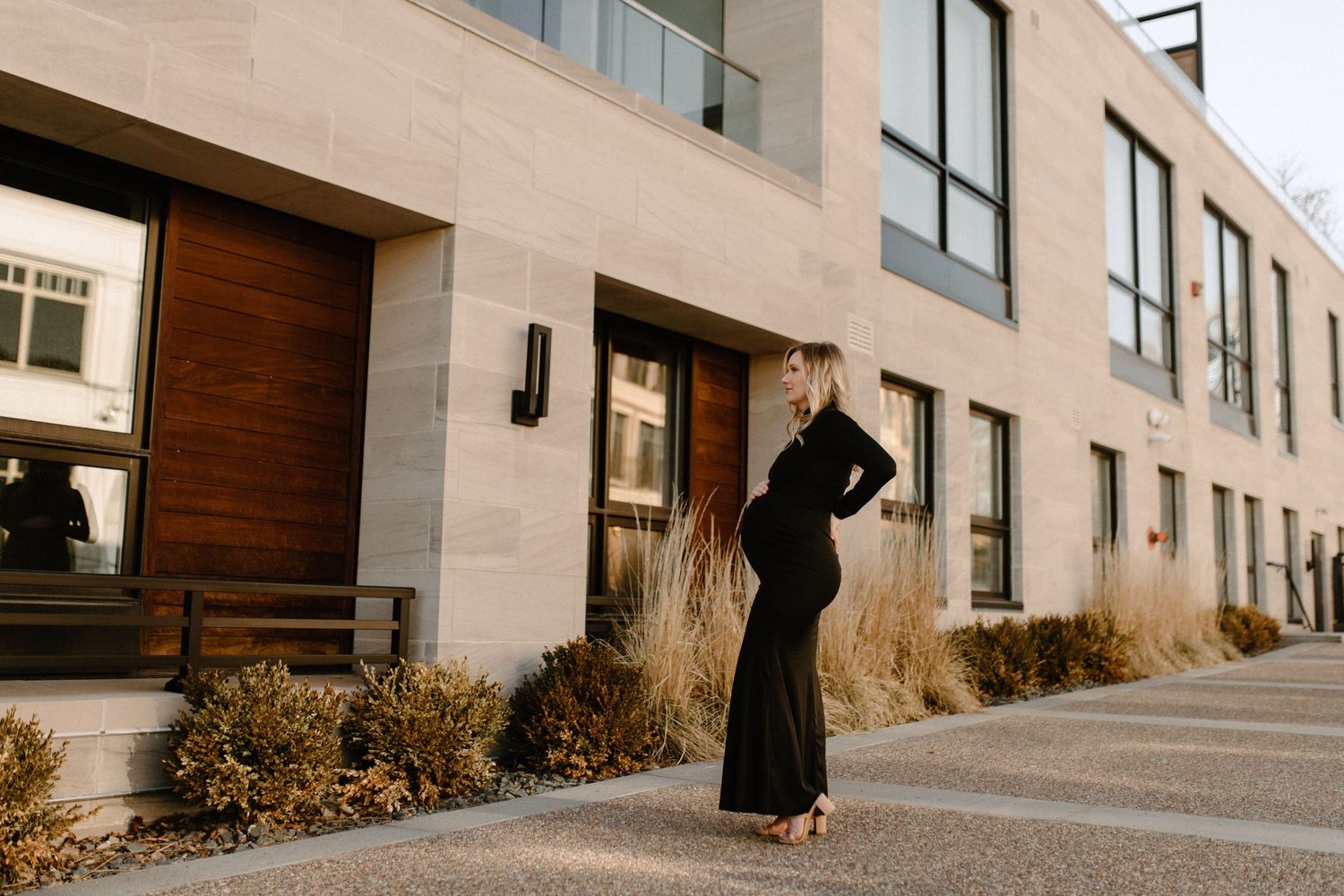Elegant formal portrait outside modern building with glass and stone architecture.